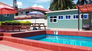 a swimming pool with a picnic table and an umbrella at My dad's cottage in Sekondi-Takoradi