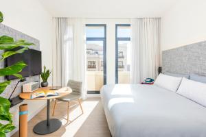 a bedroom with a bed and a desk with a computer at INNSiDE by Meliá Madrid Gran Vía in Madrid
