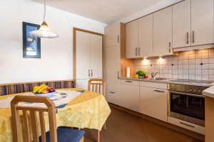 a kitchen with a table with a bowl of fruit on it at Biene Natururlaub am Moosbachhof mit Dolomitenblick in Collalbo +21 photos