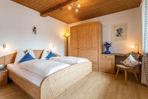 a bedroom with a large bed with blue pillows at Biene Natururlaub am Moosbachhof mit Dolomitenblick in Collalbo