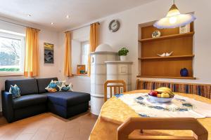 a living room with a table and a couch at Biene Natururlaub am Moosbachhof mit Dolomitenblick in Collalbo