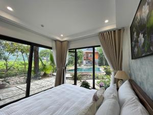 a bedroom with a bed and a large window at Mai Châu Home in Mai Châu