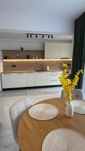 a living room with a table and a kitchen at Apartament Luna in Şelimbăr