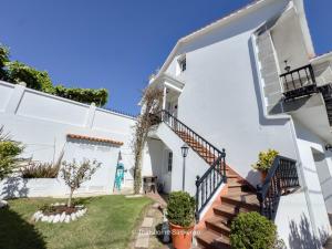 a white house with stairs and a yard at Chalet Sobre do Valo in Sanxenxo