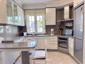 a kitchen with white cabinets and a counter top at Chalet Sobre do Valo in Sanxenxo
