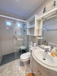 a bathroom with a toilet and a sink and a shower at Chalet Sobre do Valo in Sanxenxo