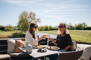 two women sitting at a table with glasses of wine at Resort Land & Zee in Scharendijke