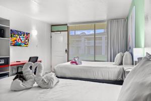 a hotel room with two beds with people laying on the floor at Disney Studio 2 Queens & Shuttle in Kissimmee +20 photos