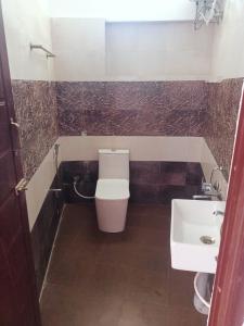 a bathroom with a toilet and a sink at Wander homes in Ooty