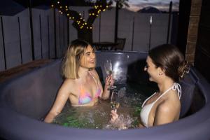 two women in a bath tub with glasses of champagne at Cabaña con jacuzzi privado in Caravaca de la Cruz