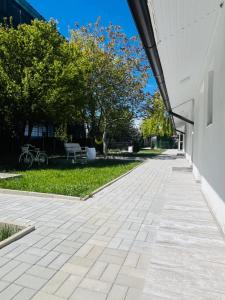 an empty sidewalk in front of a building at Mafmaf Tiny Houses - încasare cu card de vacanță in Mamaia Sat/Năvodari