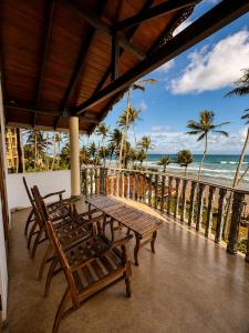 a table and chairs on a balcony overlooking the ocean at Kabalana Surf Hostel in Ahangama