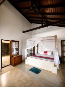 a bedroom with a bed with a canopy at Kabalana Surf Hostel in Ahangama