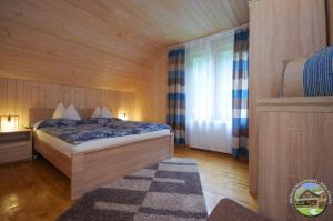 a bedroom with a bed in a wooden room at Krókusz Kulcsosház - Boga in Boga