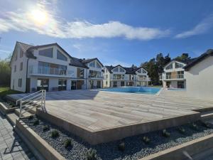 an image of a house with a swimming pool at Apartamenty Miku - Łeba in Żarnowska