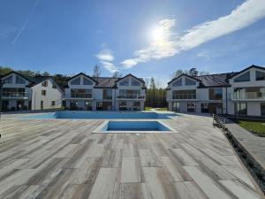 an image of a mansion with a large swimming pool at Apartamenty Miku - Łeba in Żarnowska