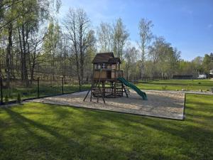 a playground with a slide in a park at Apartamenty Miku - Łeba in Żarnowska