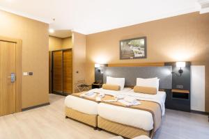 a hotel room with a large bed with two pillows at Orange Hotel & Spa in Şişli