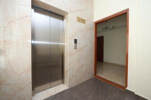 a metal elevator in a hallway with a door at Hotel Amulya Relax Inn in Bangalore
