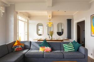 a living room with a gray couch with colorful pillows at Pier Court Apartments Brighton in Brighton & Hove