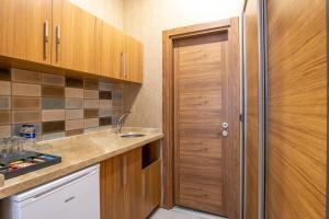 a kitchen with wooden cabinets and a wooden door at Orange Hotel & Spa in Şişli