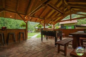 a large outdoor patio with a ping pong table and a bench at Krókusz Kulcsosház - Boga in Boga