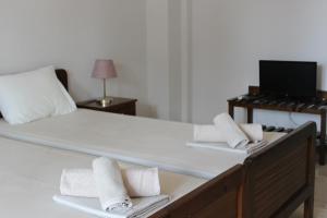 a bedroom with a large bed with towels on it at Anthema Apartments in Kalogria