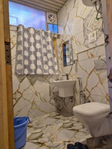 a bathroom with a toilet and a stone wall at Hotel Dilli Darbar and Restaurant in Bandipura