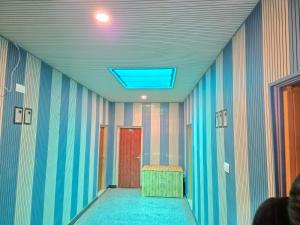 a hallway with a red door and striped walls at Hotel Dilli Darbar and Restaurant in Bandipura