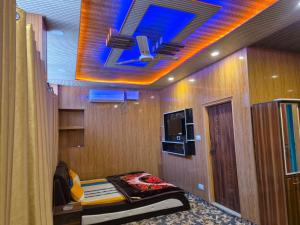 a room with a bed and a tv on the ceiling at Hotel Dilli Darbar and Restaurant in Bandipura