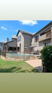 a building with a fence and a swimming pool at Matumi Golf Lodge in Nelspruit