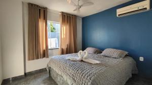 a bedroom with a bed with two white shoes on it at Casa Cris cabo frio in Cabo Frio +43 photos