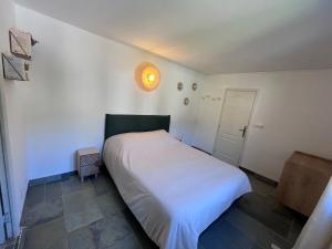 a bedroom with a white bed in a room at Maison Erbalunga in Brando