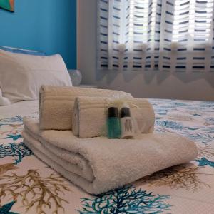 a pile of towels on top of a bed at Blue Sicily Apartment in Roccalumera