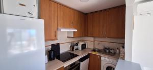 a small kitchen with wooden cabinets and a sink at A & G Casares Costa in San Luis de Sabinillas