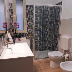 a bathroom with a shower with a toilet and a sink at Blue Sicily Apartment in Roccalumera +18 photos