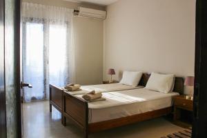 a bedroom with a bed with two towels on it at Anthema Apartments in Kalogria +26 photos