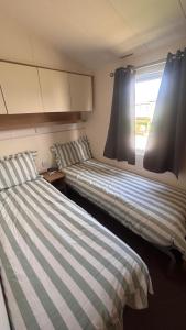 two beds sitting next to each other in a room at Lyons Robin Hood Hazel Park 6 in Rhyl