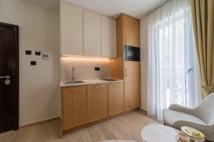 a small kitchen with wooden cabinets and a window at Klaris Guest house in Budva