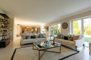 a living room with two couches and a table at Sea Estate House in Littlehampton