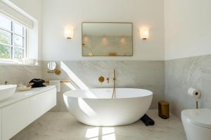 a white bathroom with a tub and a sink at Sea Estate House in Littlehampton +61 photos