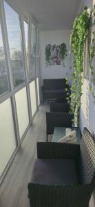 a room with chairs and a table and windows at Cozy Stay Širvintos in Širvintos
