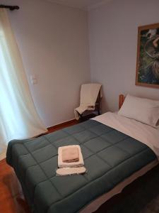 a bedroom with a bed with two towels on it at Menelais Guesthouse in Khotoússa