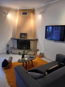 a living room with a couch and a fireplace at Menelais Guesthouse in Khotoússa