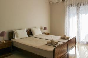 a bedroom with a large bed with two towels on it at Anthema Apartments in Kalogria