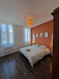 a bedroom with a large bed and a large window at Hyper centre Libourne - Cosy & tout à pied in Libourne