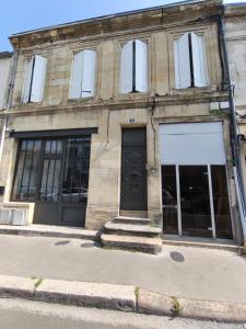 a stone building with a black door and windows at Hyper centre Libourne - Cosy & tout à pied in Libourne