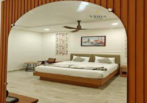 a bedroom with a large bed with a ceiling at Hotel Vibha Grand in Karīmnagar