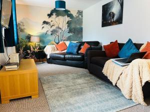 a living room with a couch and a table with a laptop at Scarisbrick Apartment Sleeps 6 in Scarisbrick