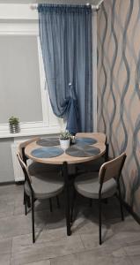 a wooden table with two chairs and a table with apertureperture at Cozy Stay Širvintos in Širvintos